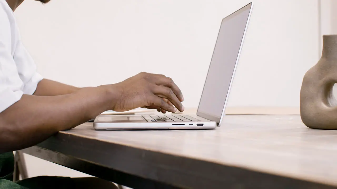 American Clerk In Apron Sitting In Front Of Laptop And Typing On Keyboard 1