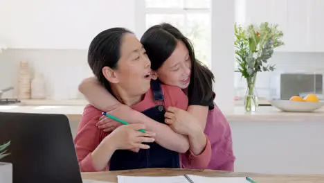 Hug child and mother working with a laptop