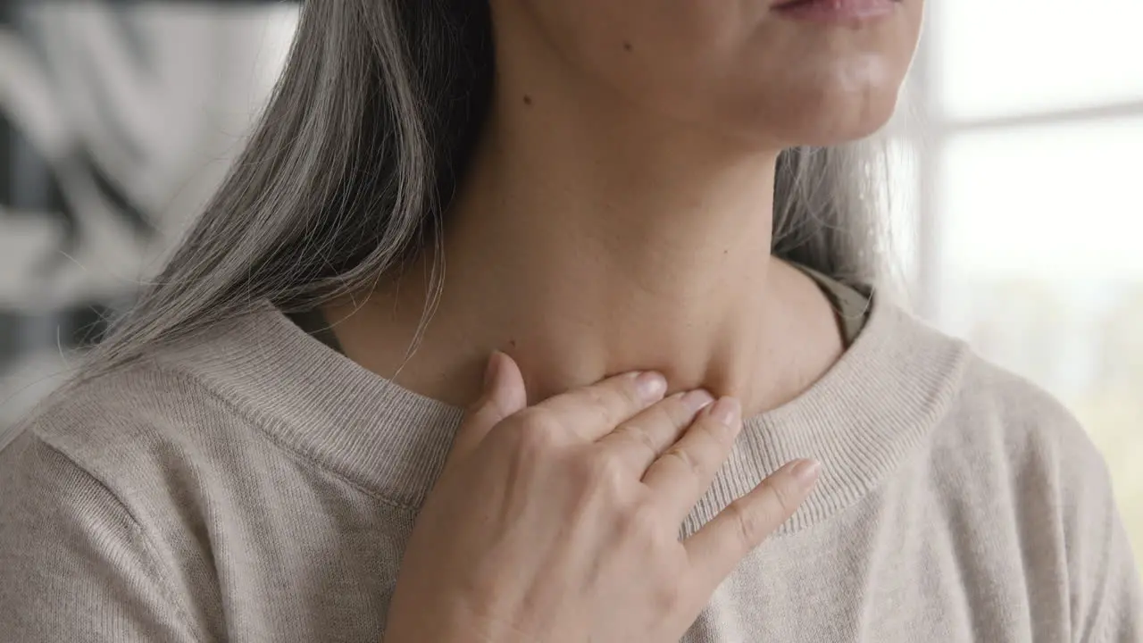 Close Up Of A Woman Having Throat Pain And Touching Her Neck