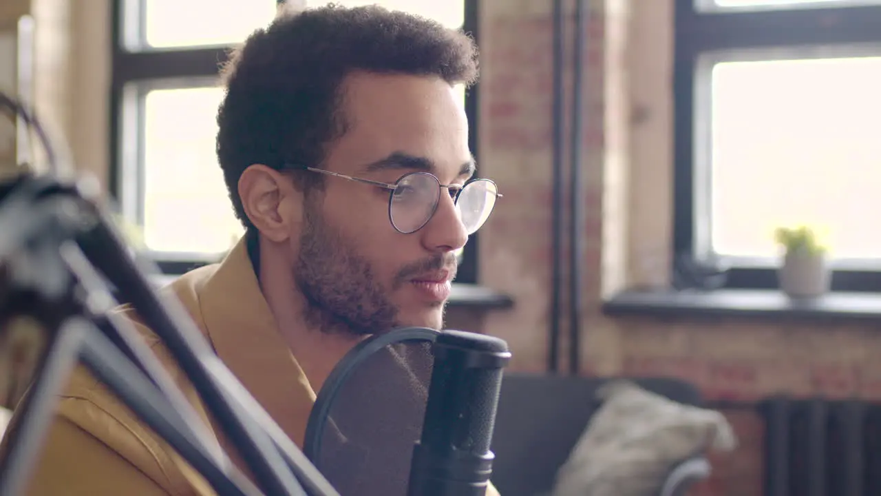 Close Up View Of Man With Eyeglasses Talking Into A Microphone Recording A Podcast