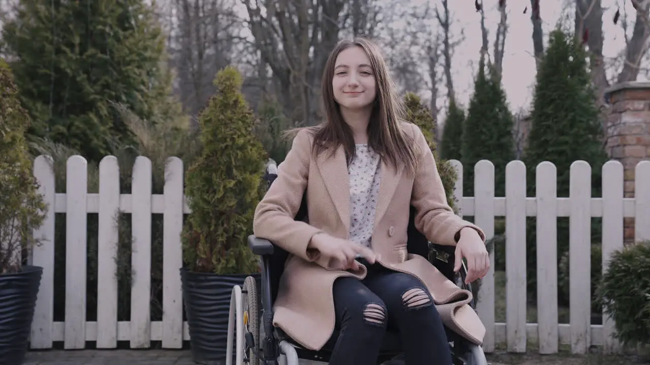 Front View Of A Woman In Wheelchair Waving At Camera