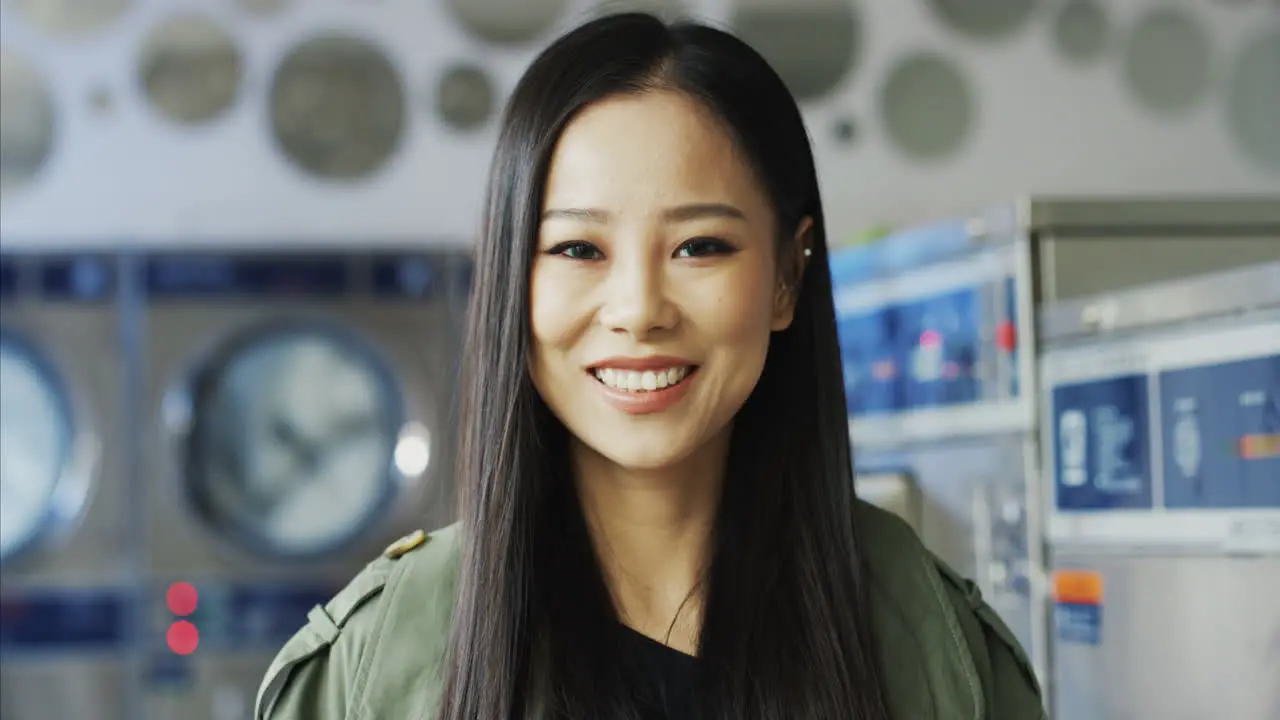 Close Up Of Beautiful Young Stylish Woman Smiling Joyfully To Camera In Laundry Service Room