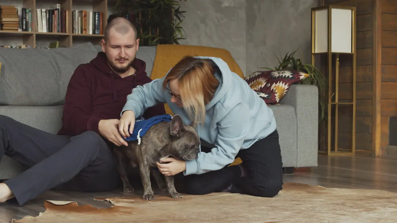 Couple Sitting On The Floor Leaning On The Sofa