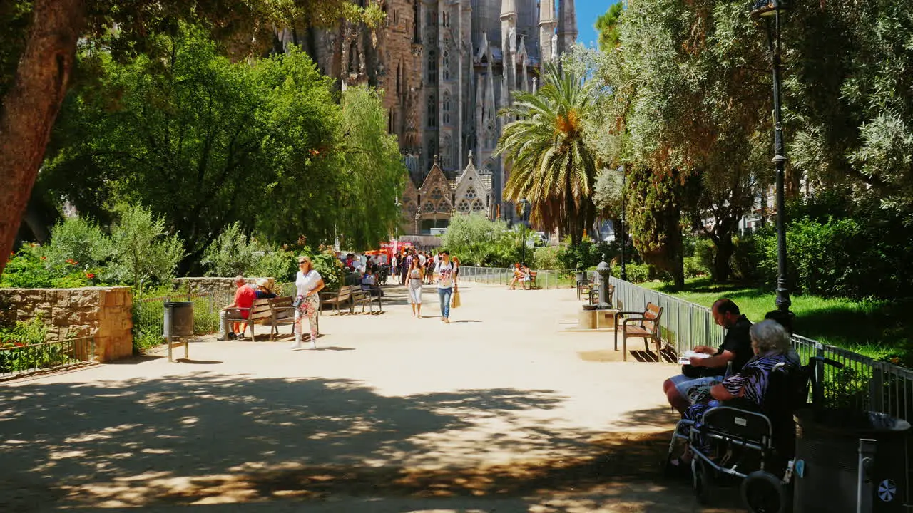 The Famous Sagrada Familia Church In Barcelona Tourists Walking The Camera Moves Toward The Temple