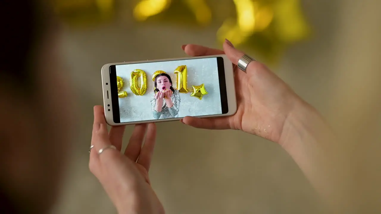 Hands Holding A Phone Showing A New Year's Eve Video