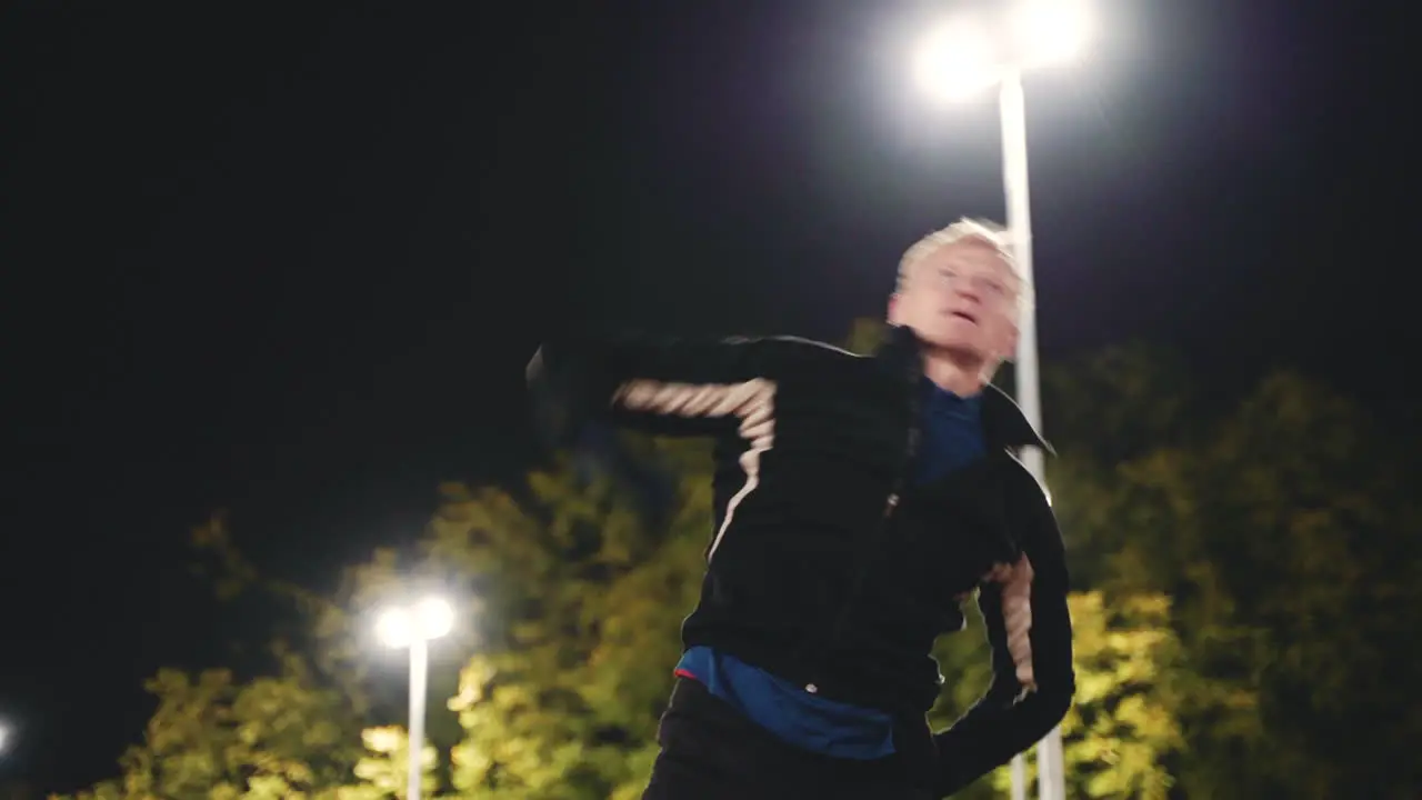 Sportive Blond Man Doing Stretching Exercises Before Training In The Park At Night 1