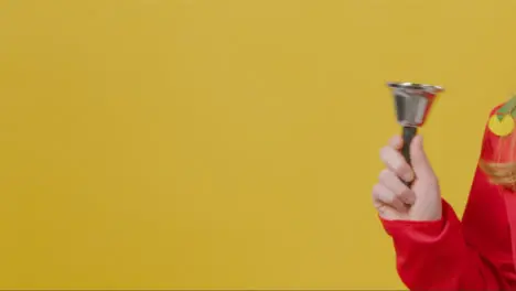 Close Up Girl in Festive Outfit Ringing Bell with Copy Space