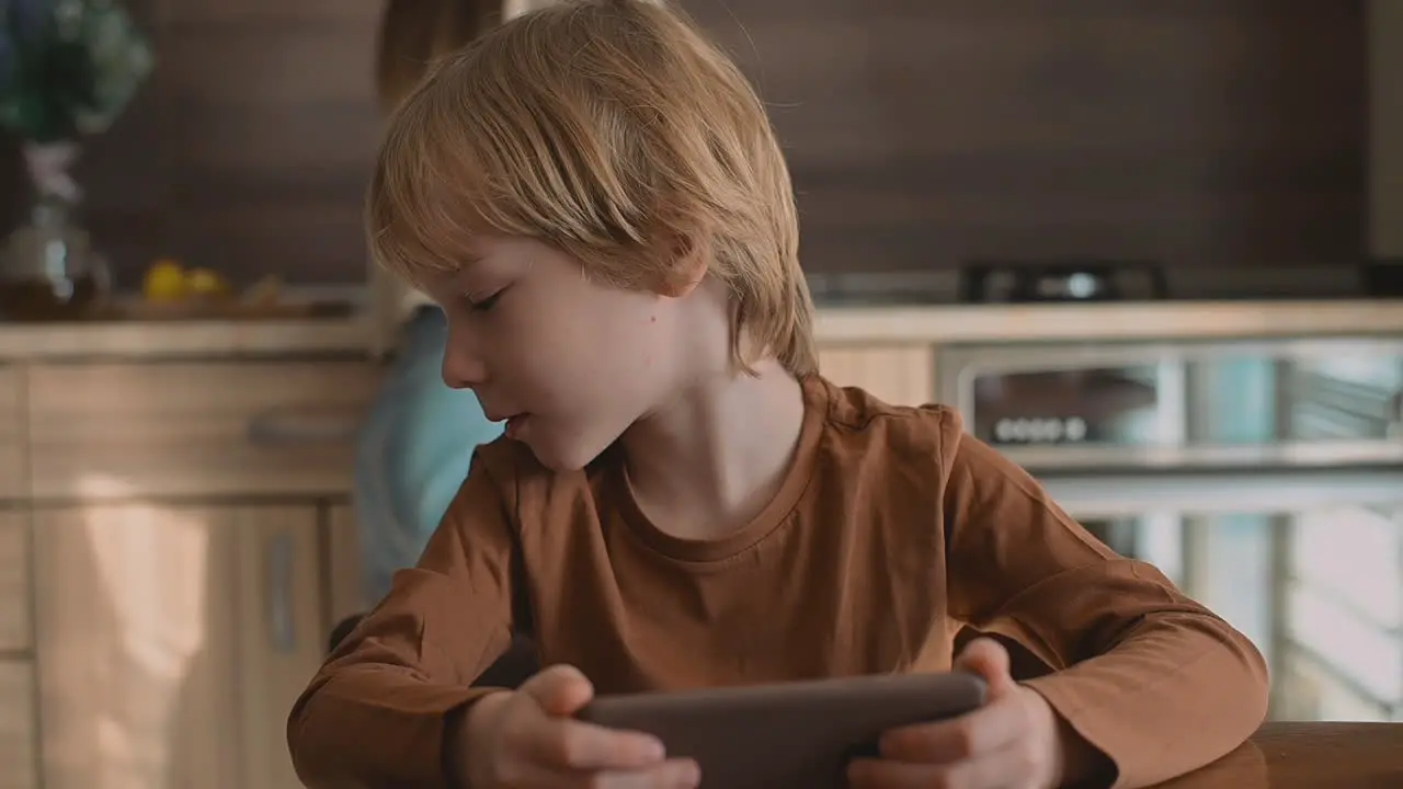 Little Boy And Older Sister Watching Smartphone At Home