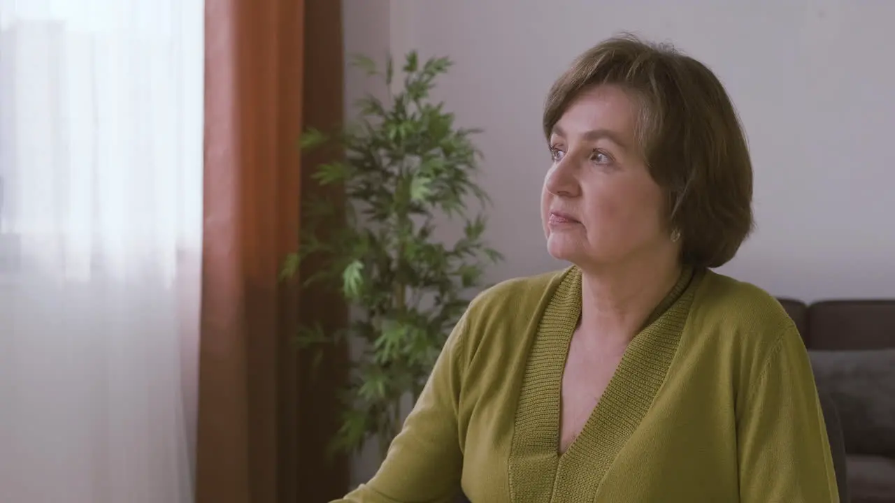 Senior Woman With Gray Hair Sitting And Looking At Side