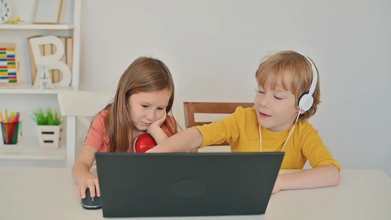 Little Boy And Girl Using A Laptop And Having An Online Class At Home