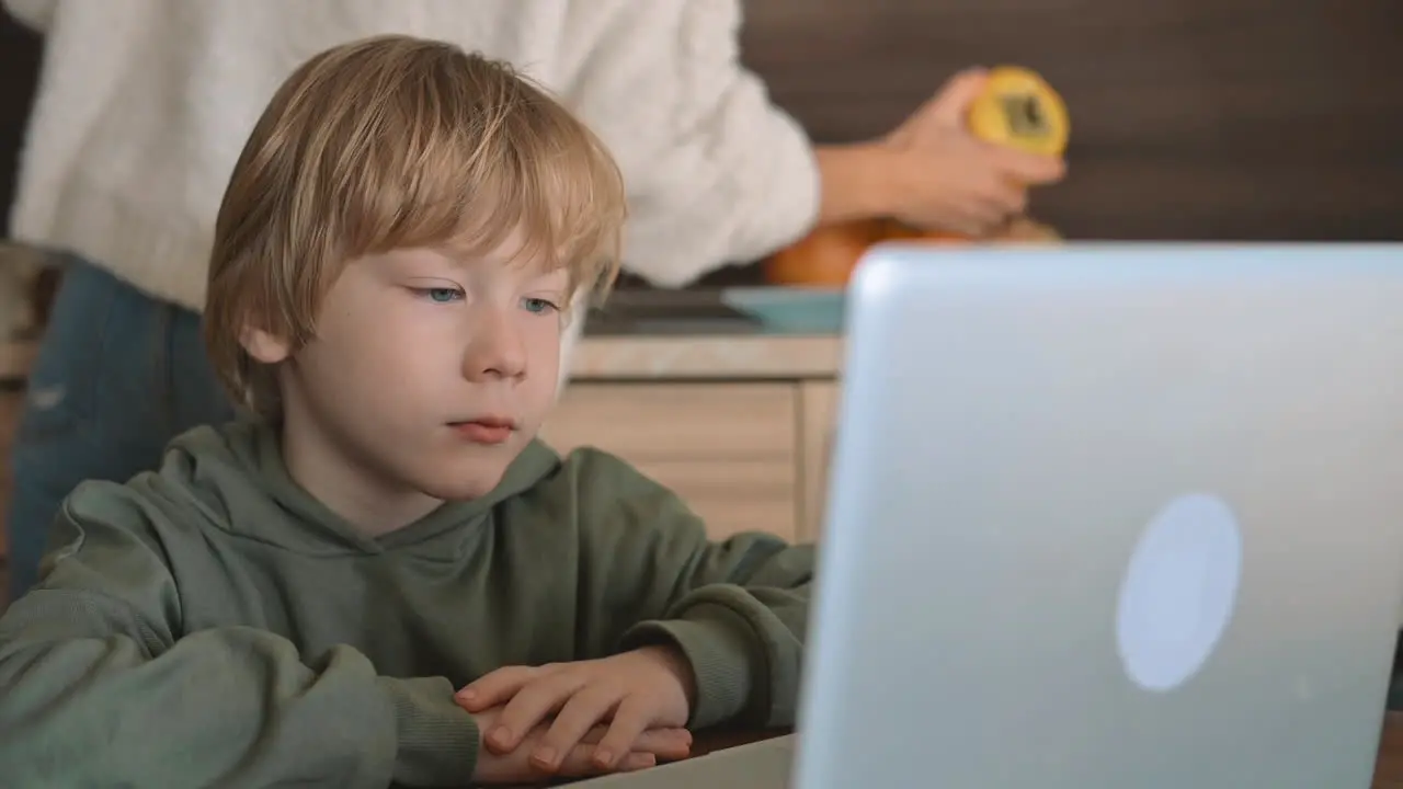 Little Boy And Mother Watching Laptop At Home