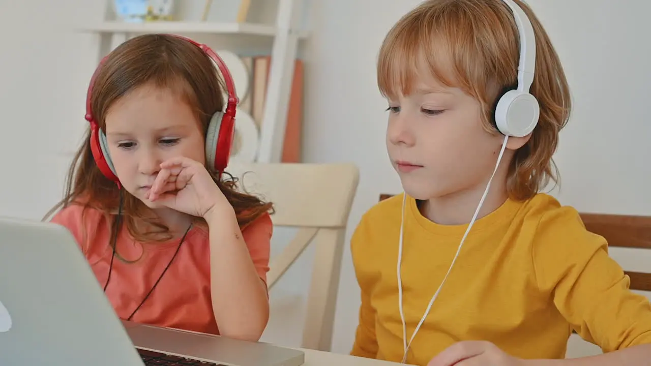 Little Boy And Girl Using A Laptop At Home