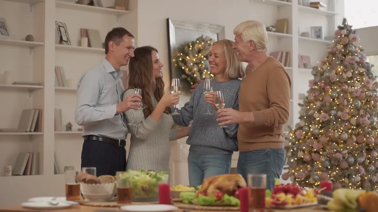 Young Adults And Their Elderly Parents Toasting And Celebrating Christmas At Home