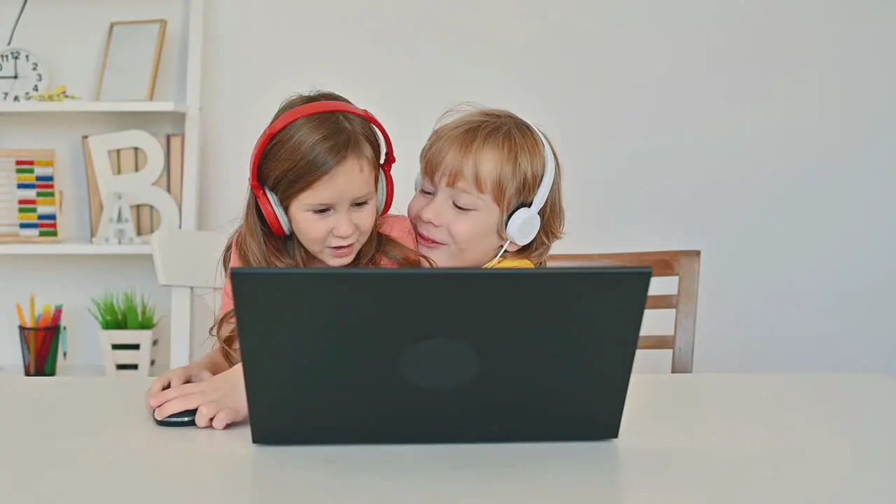 Little Boy And Girl Using A Laptop And Having Fun At Home 1