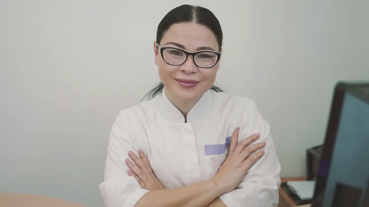 Female Doctor With Glasses Looks Directly Into The Camera