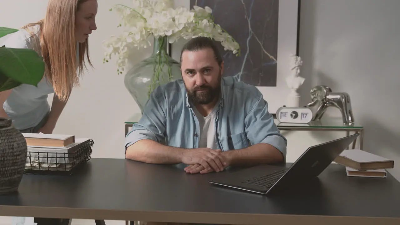 A Bearded Man Patiently Endures A Woman's Long Talk While Looking At The Camera