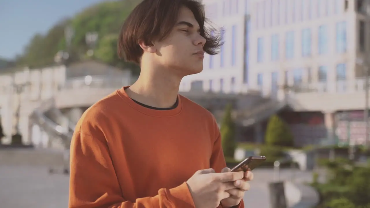 Teenager Typing On His Cell Phone