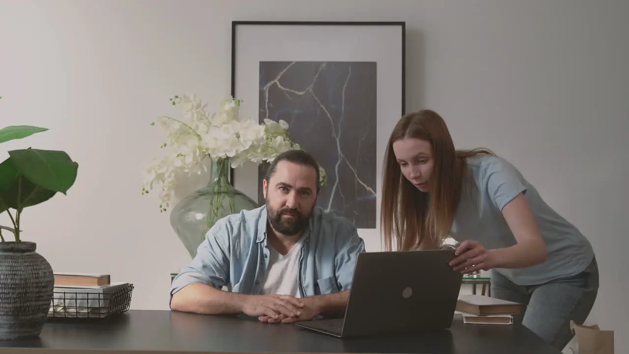 A Bearded Man Holds On To A Woman's Anger While Looking At The Camera