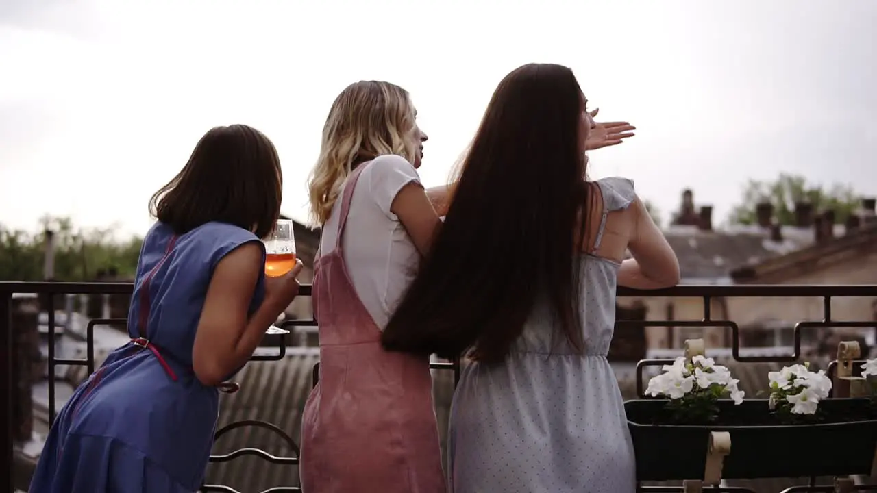 Three Female Friends Enjoying Hen Party On The Terrace Backside View