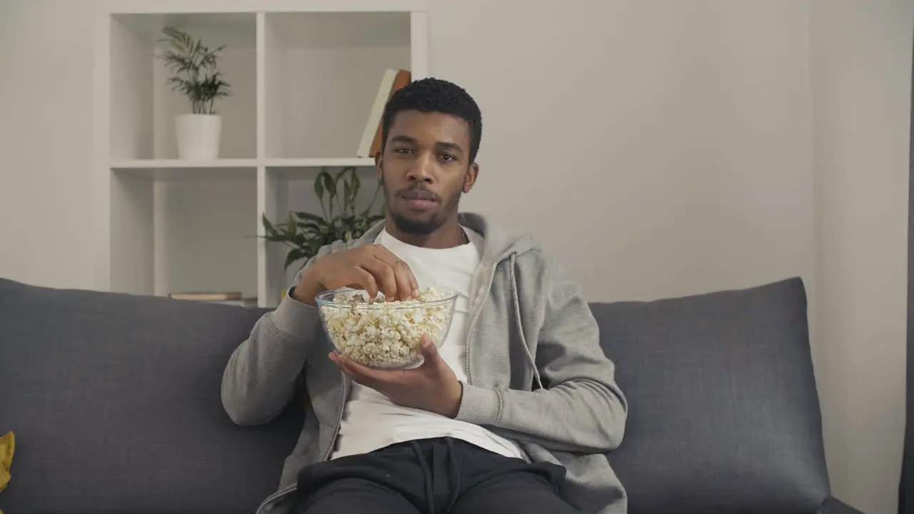 Young Male Looking Directly At The Camera And Showing Us A Popcorn