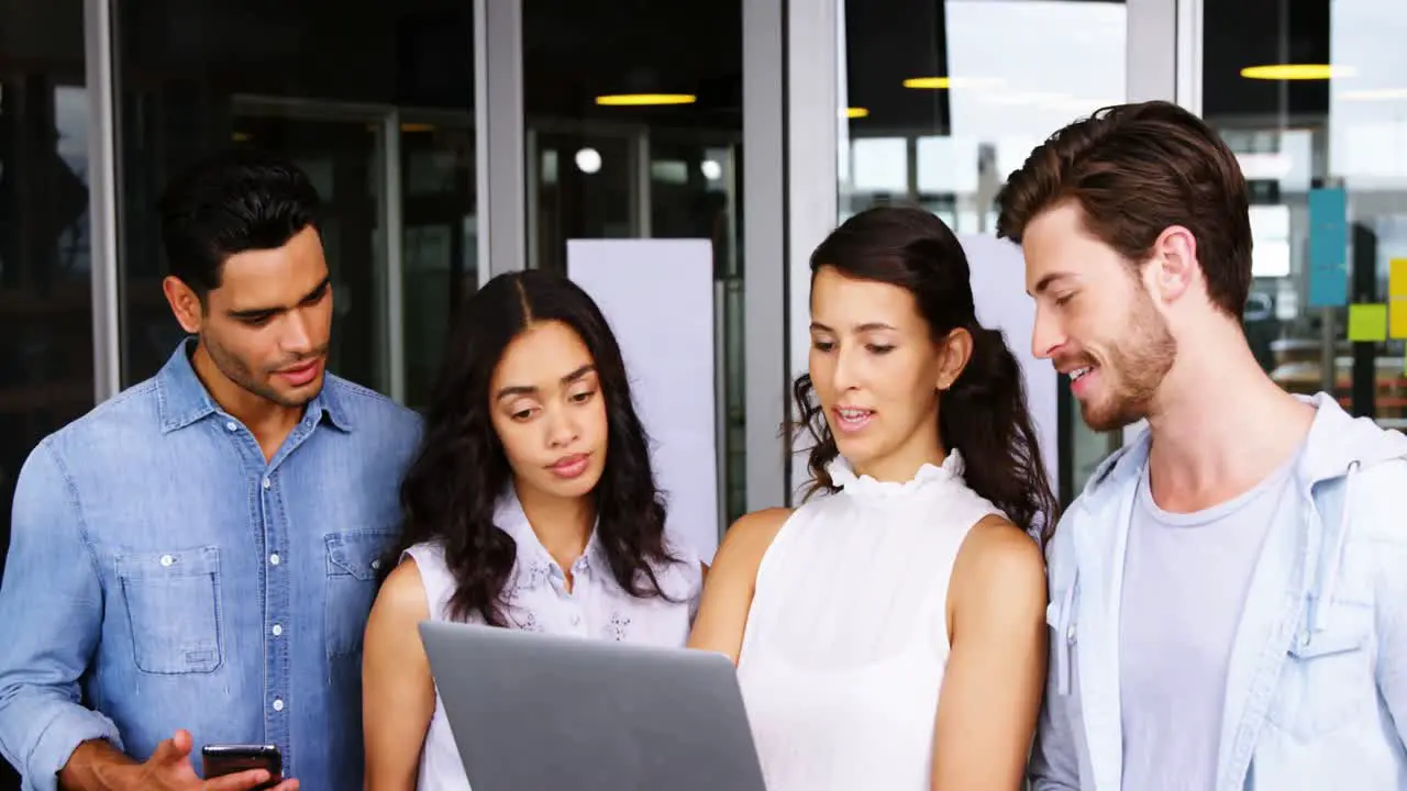 Executives having discussion over laptop