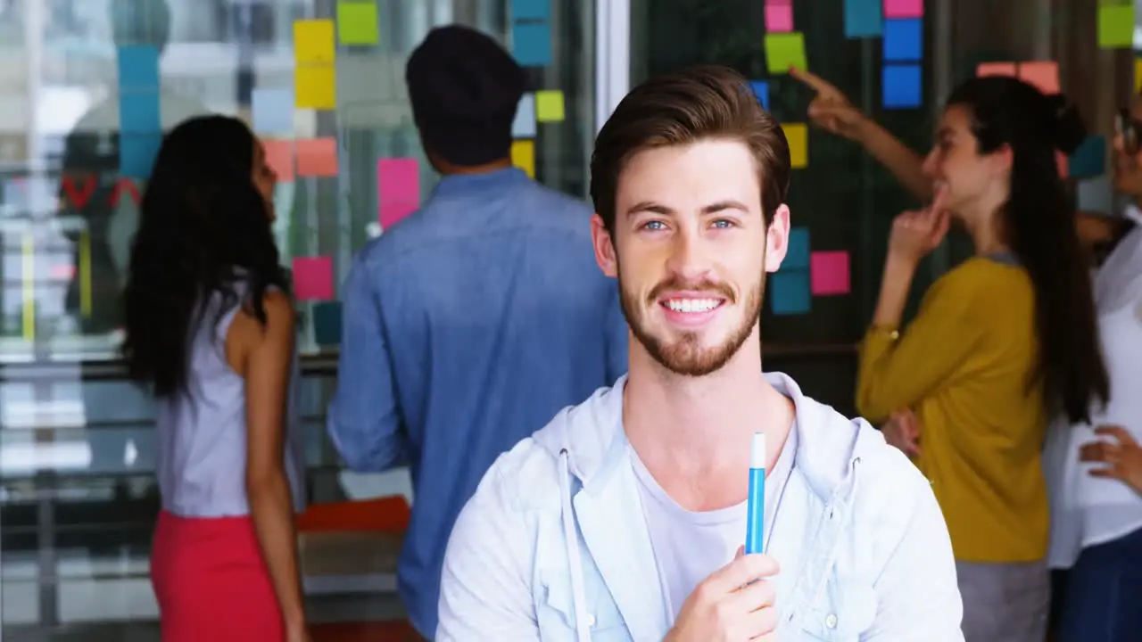 Portrait of smiling male executive standing with marker