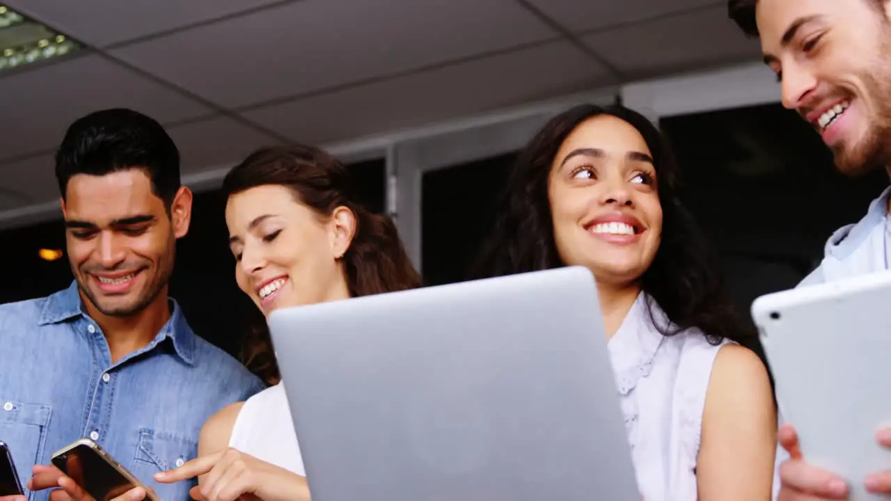 Happy executives using digital tablet laptop and mobile phone