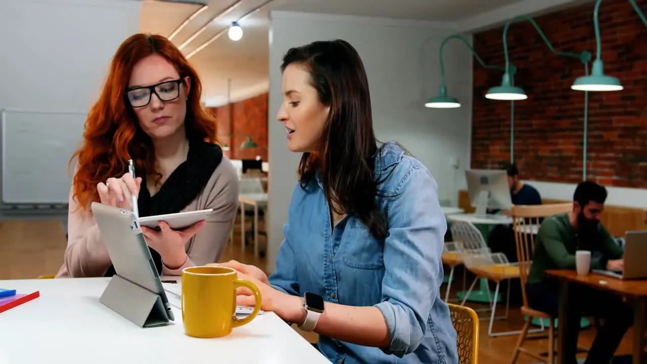 Female executives discussing over digital tablet