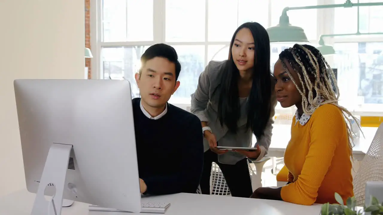 Business executives having discussion over personal computer