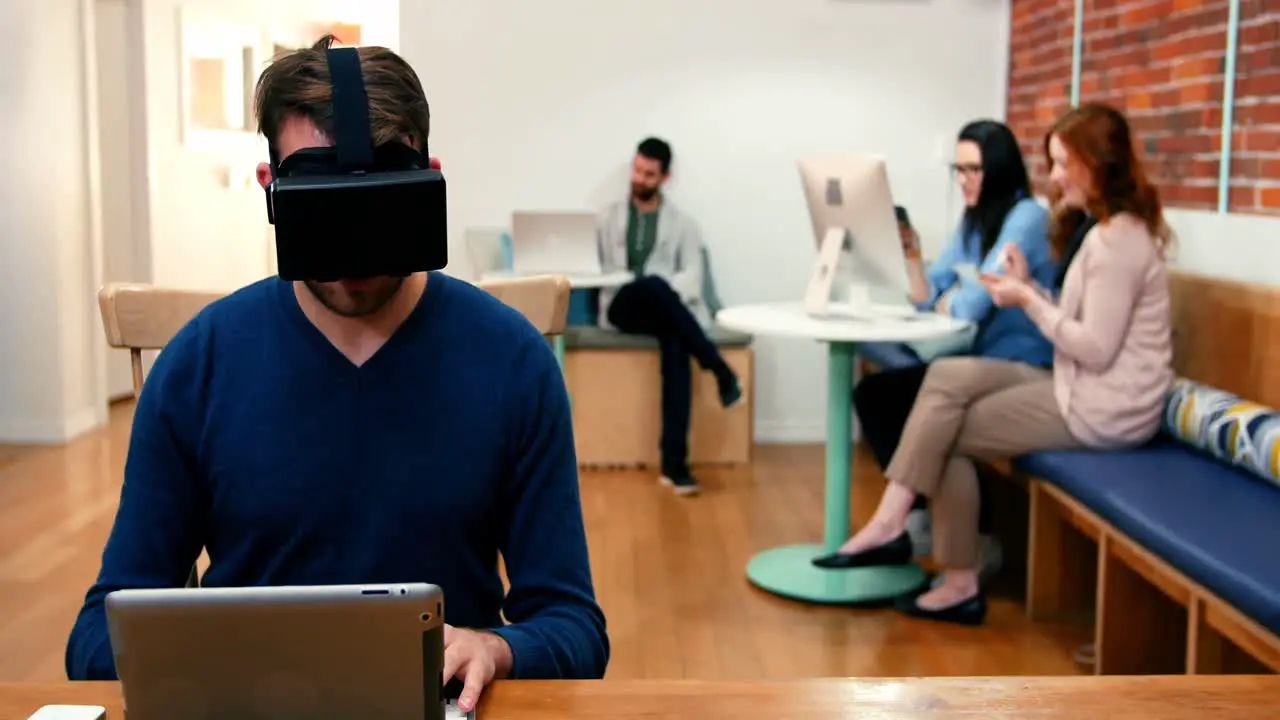 Male executive wearing virtual reality headset while using digital tablet