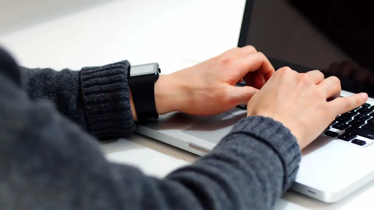 Mid section of male executive using laptop at desk