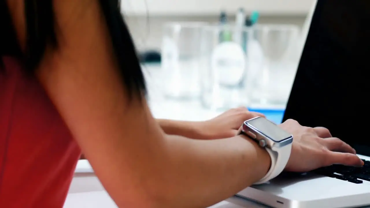 Mid section of female executive using laptop at desk