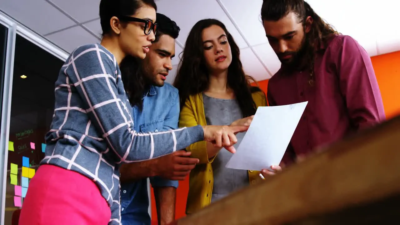 Smiling graphic designers discussing over document