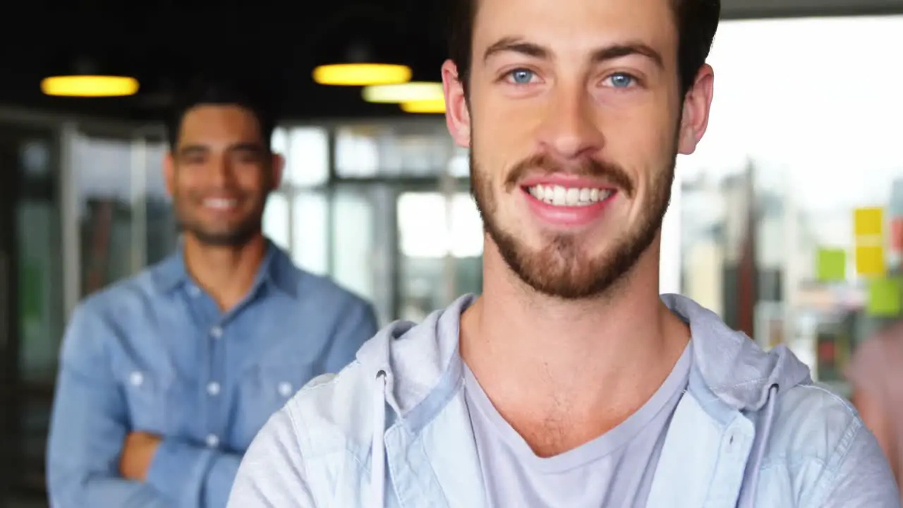 Portrait of happy male executives standing with arms crossed