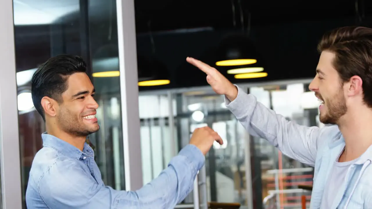 Male executives giving high-five to each other