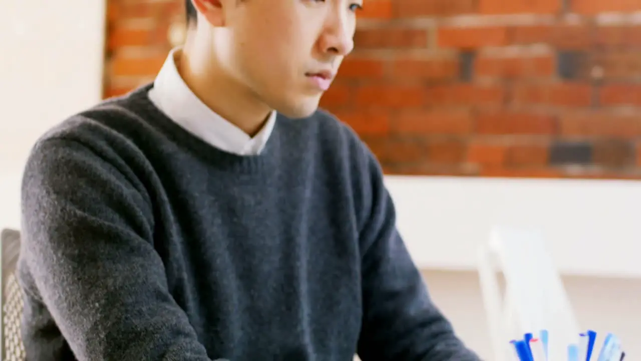 Male executive using laptop at desk