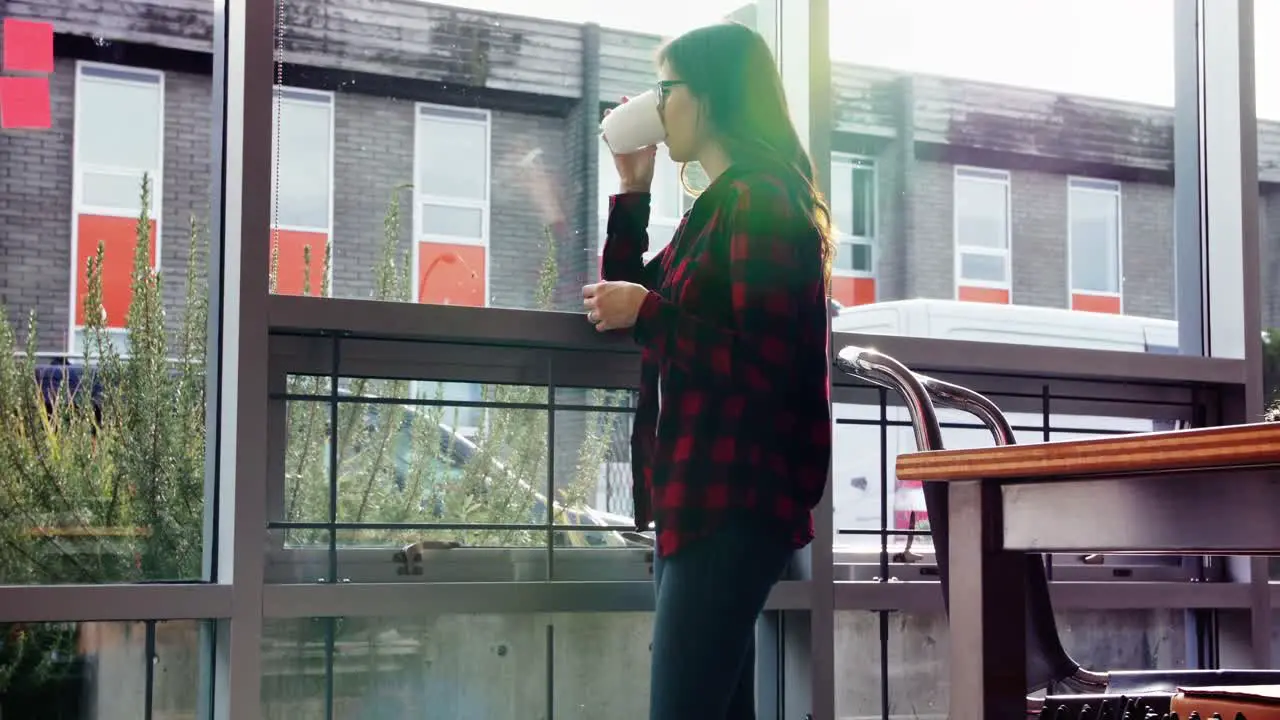 Thoughtful female executive drinking coffee