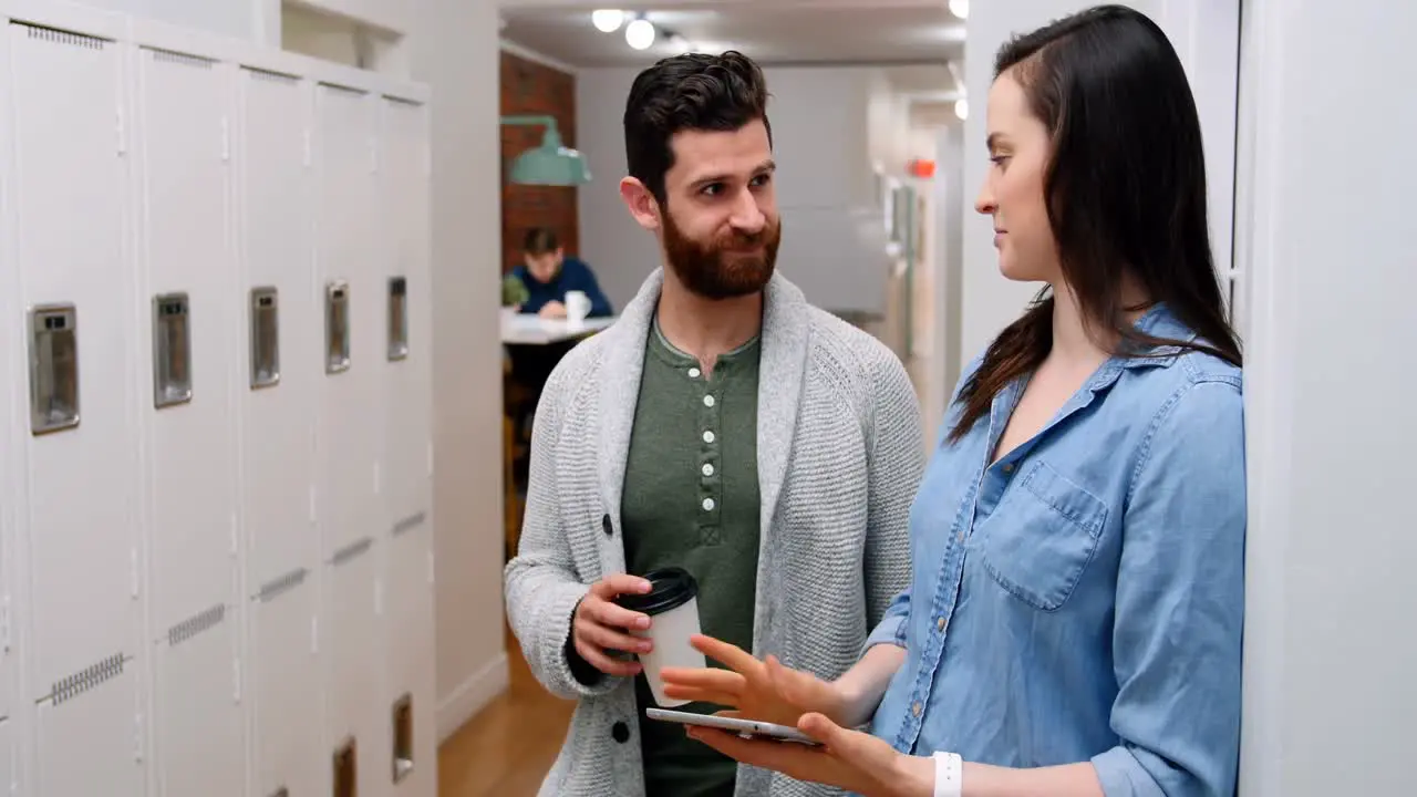 Business executives discussing over digital tablet in locker room