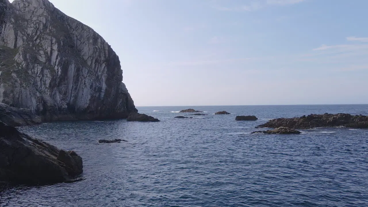 Zoom In Of Blue Sea Waves Breaking On Rocks On A Sunny Day