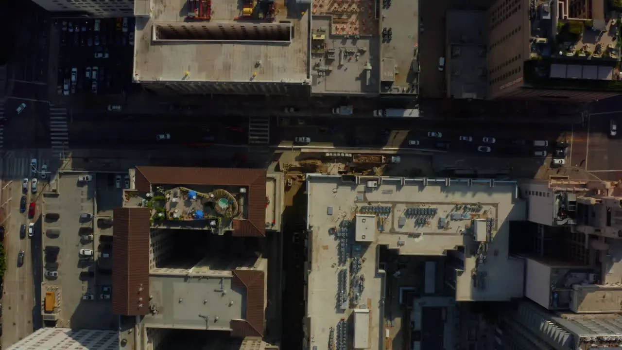 AERIAL Birds Eye View over Streets of Downtown Los Angeles california with cars Traffic and rooftops Pools Daylight