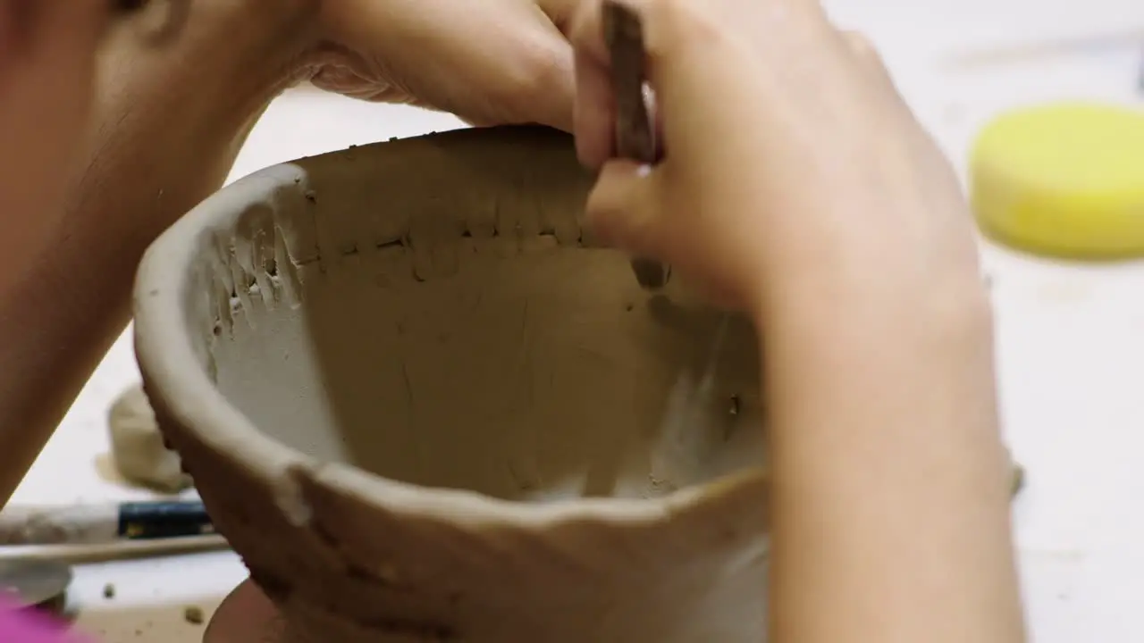 Inspiring Footage Depicting a ceramic artist Crafting Clay Using a Unique Approach Skillfully Incorporating Sewing Techniques into the Creative Process for a Distinctive