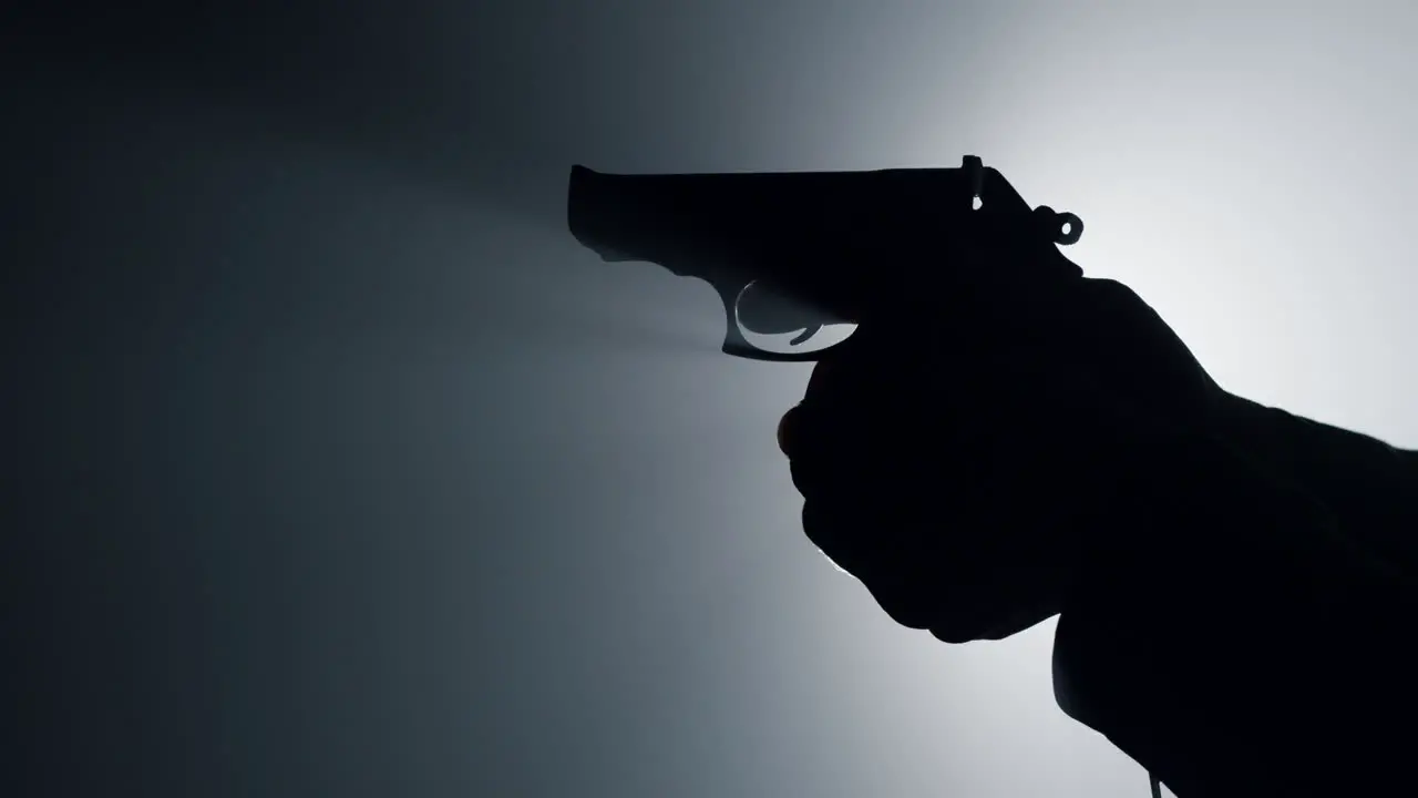 Silhouette male hand cocking gun trigger Unknown criminal cocking trigger