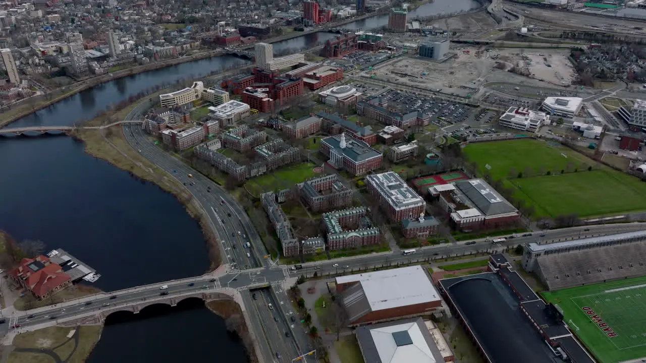 Aerial view of complex of classical red brick building on river waterfront Harvard Business School site and busy road leading around Boston USA