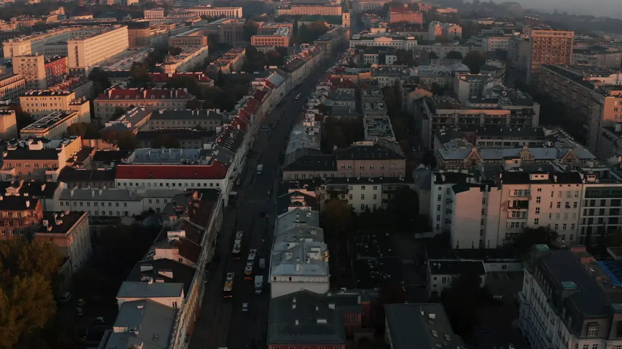 Fly above historic town centre lit by morning sun Large buildings and palaces at sunrise Warsaw Poland