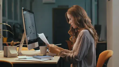 Focused business woman working with documents at night office