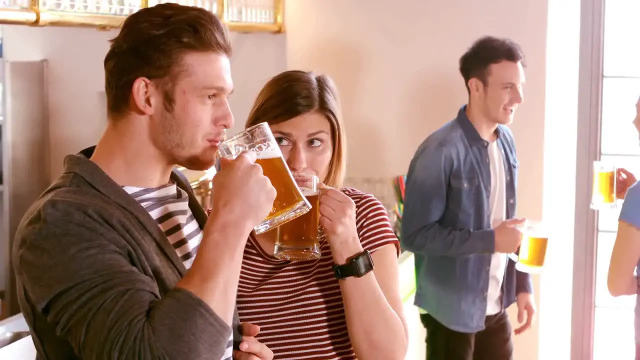 Couple interacting while having a glass of beer