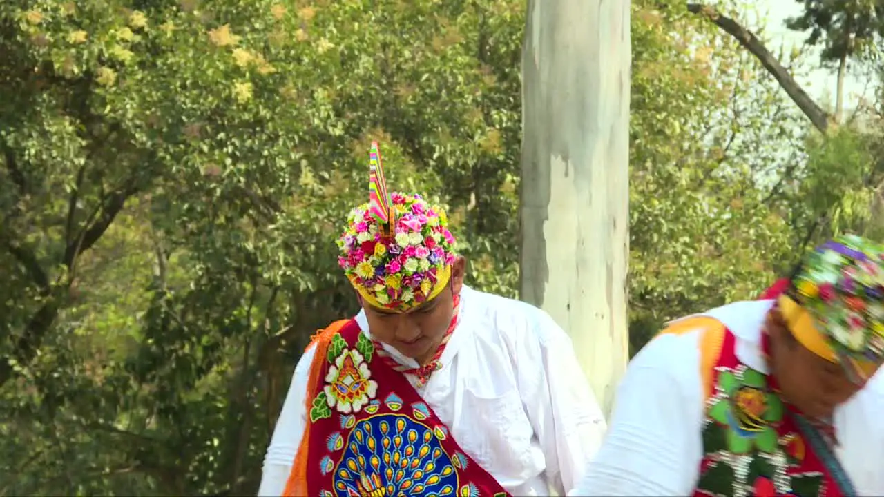 Mexican Men known as Papantla Flyers dressed with feathers playing music