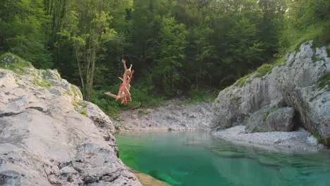 Two friends excitedly jumping into a lake together