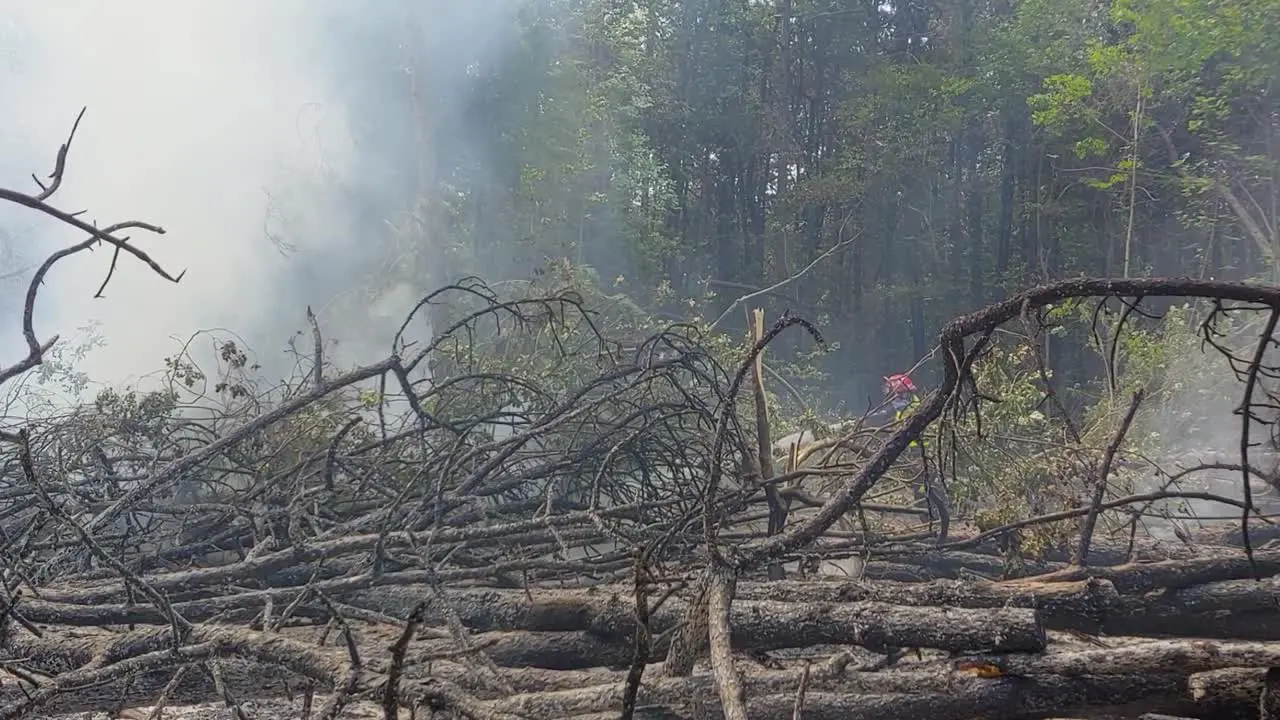 Firefighter extinguishing fire and pulling on hose on hard terrain