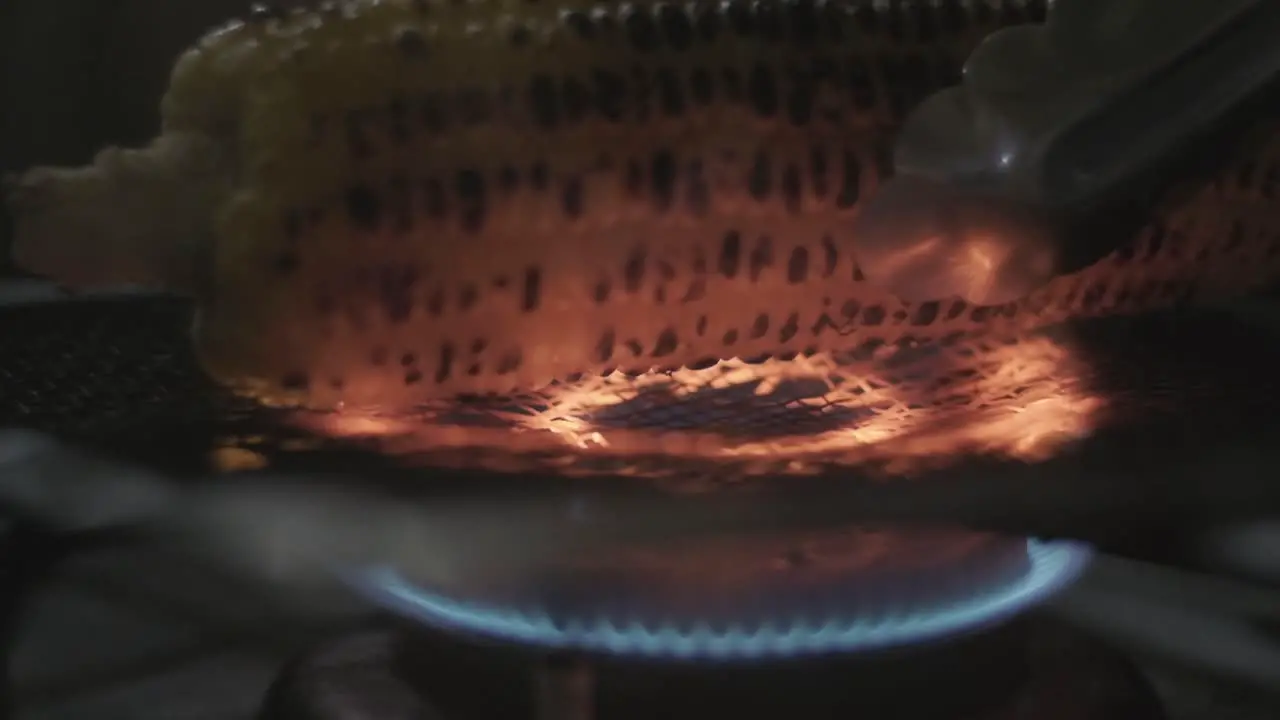 Placing Corn on the cob cooking on a gas stove over a grill slow motion